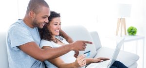 A couple making a payment using a laptop through a credit card