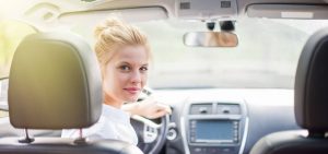 Female driving car and looking back