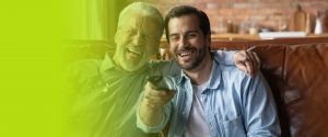 Father and son laughing and enjoying the moment while sitting on a couch